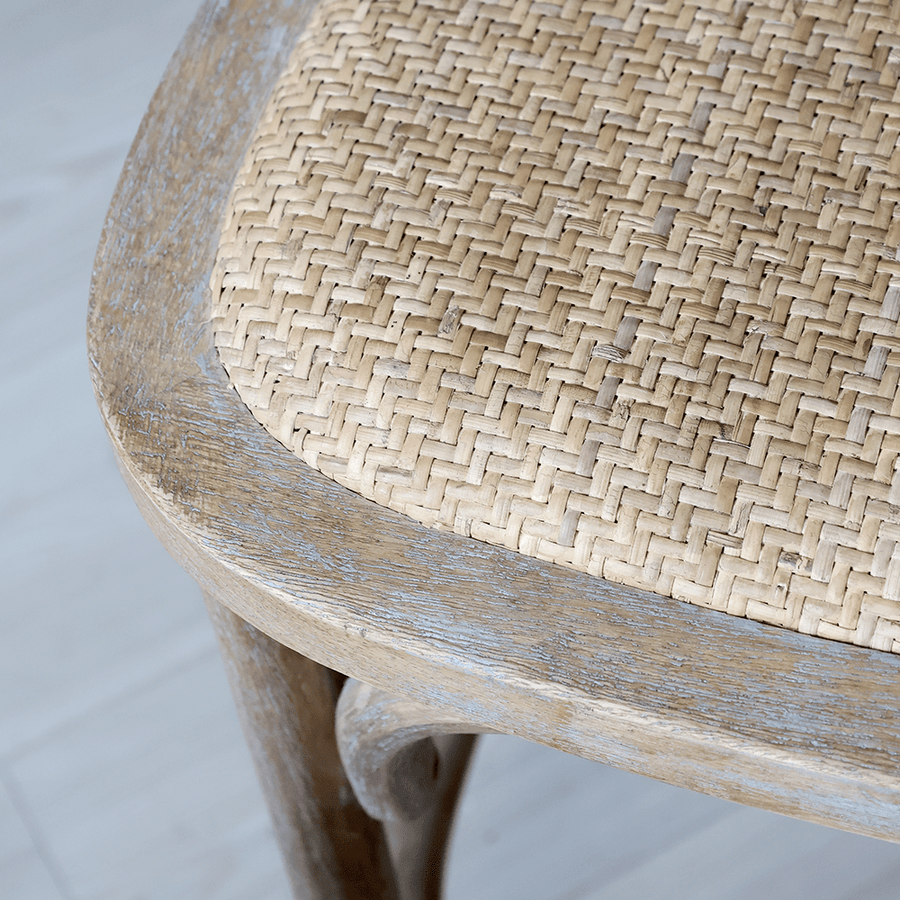 A kézműves rattan ülőfelület és fa keret találkozása közelről