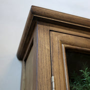 A faliszekrény felső kerete, természetes fa erezetének részletgazdag kidolgozásával.