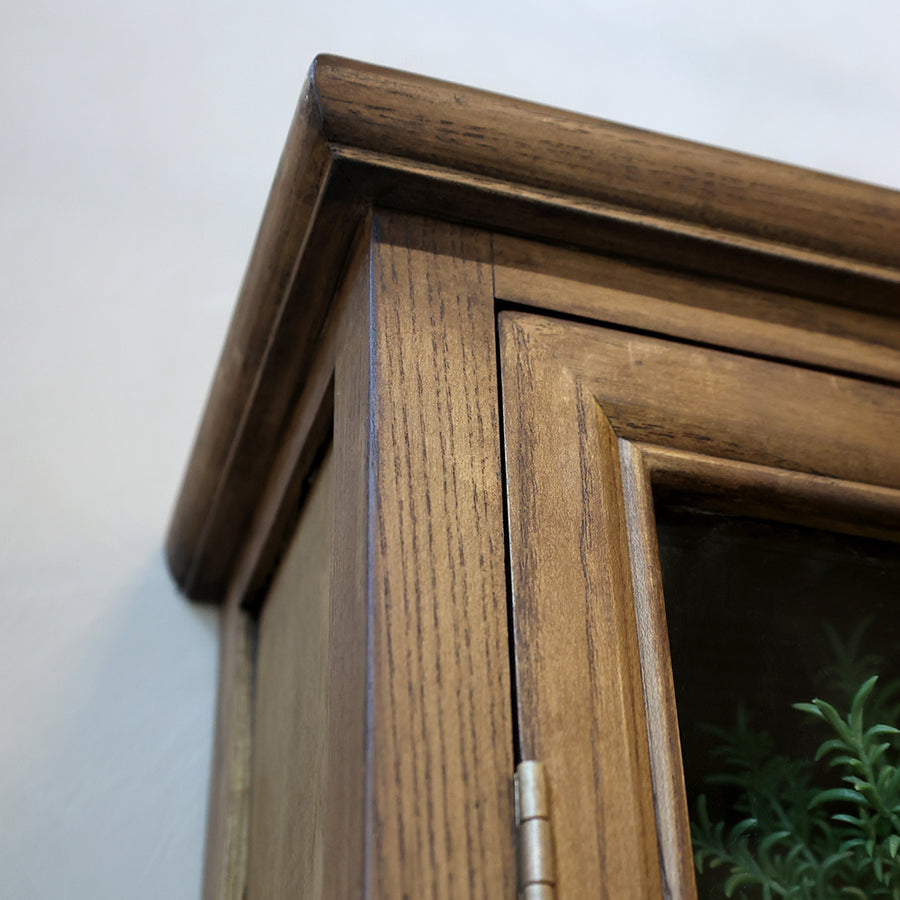 A faliszekrény felső kerete, természetes fa erezetének részletgazdag kidolgozásával.