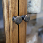 Patinás fémből készült fogantyúpár részlete, natúr fa ajtólapokon.