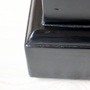 Masszív fekete lábazat részlet az Old French vintage komódszekrény alján, letisztult kidolgozással.