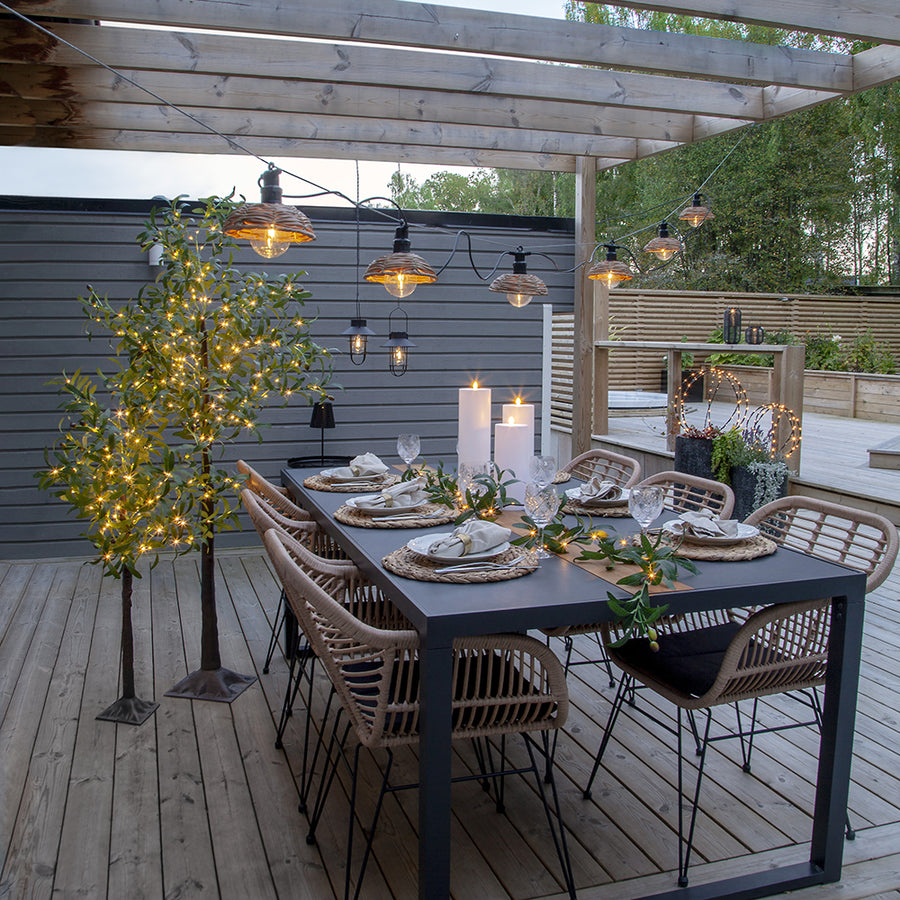 LED-es olajfa és olíva girland pergola alatt, meleg fényekkel