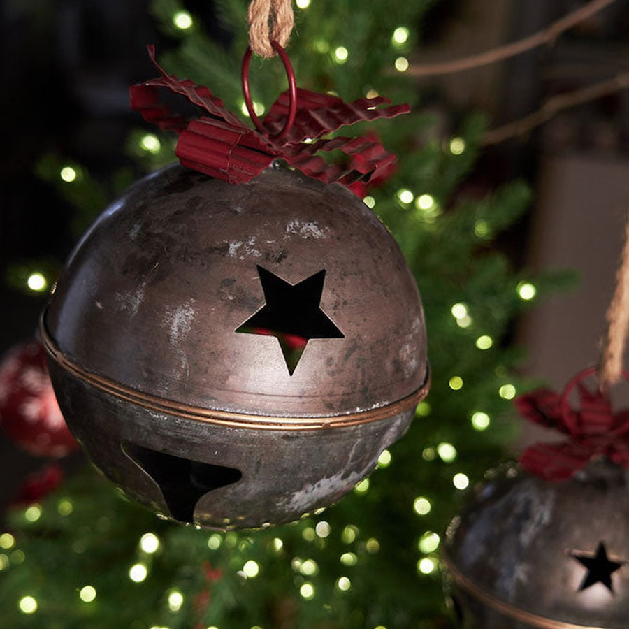 Piros színű fém masnival díszített karácsonyi kézműves bádogcsengő.