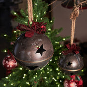 Piros színű fém masnival díszített karácsonyi kézműves bádogcsengő.