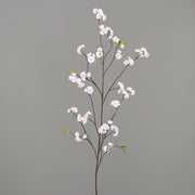 Virágzó mű cseresznyefa ág, halvány rózsaszín színű nyílt és bimbós virágokkal.