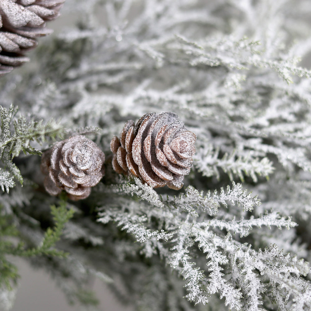 Hóval borított mű fenyő koszorú közeli részlete tobozokkal