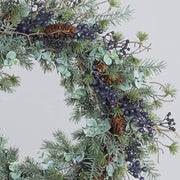 Fenyő mix koszorú közelebbi nézetben, eukaliptusz levelekkel és tobozokkal.