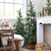 150 cm-es Pine LED műfenyő természetes nappali környezetben, kandalló mellett