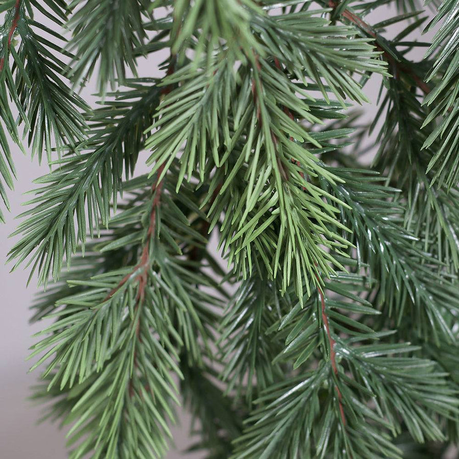 Részletfotó a PINE zöld mű fenyő ágairól és leveleiről.