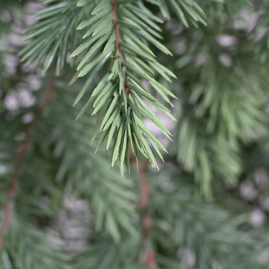 Részletfotó a PINE zöld mű fenyő ajtódísz 3D-s tűleveleiről.