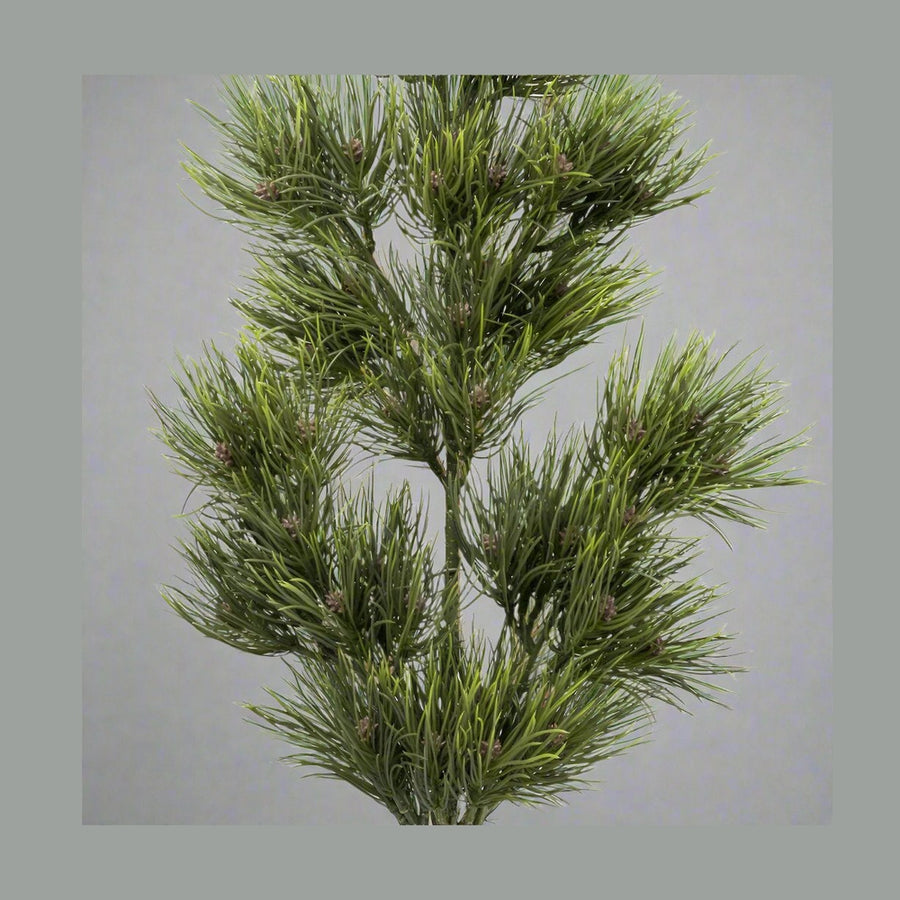 Zöld színű, mű feketefenyő ág.