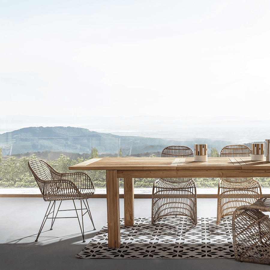 Rattan karosszék modern étkezőasztal mellett, panorámás kilátással.