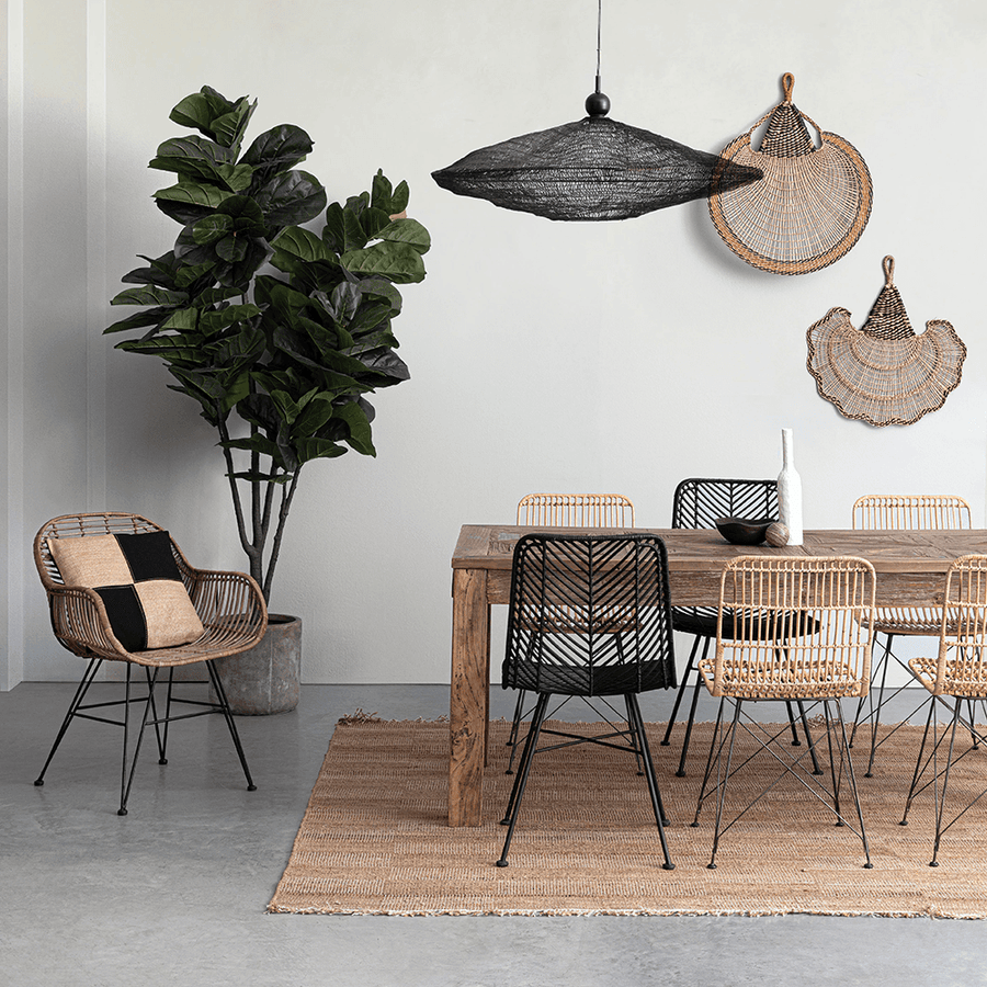 Modern étkező enteriőr rattan és fekete székekkel, fa asztallal és natúr dekorációval.