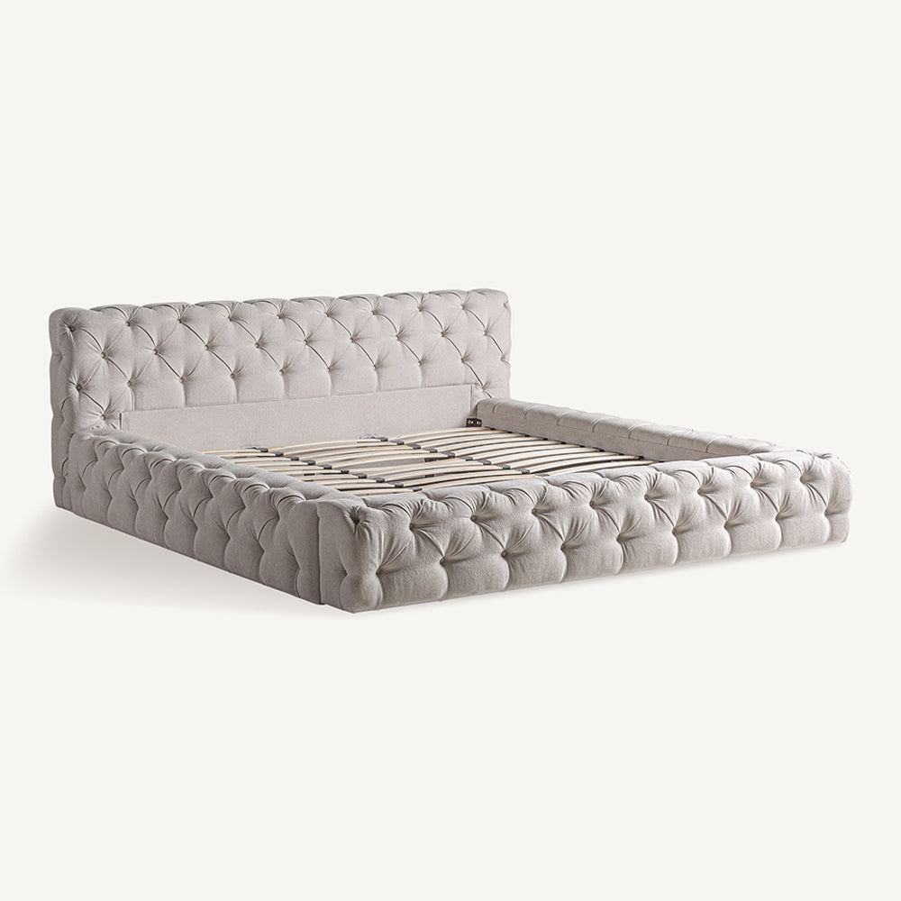 Világosbézs színű szövettel kárpitozott nagy design franciaágy.