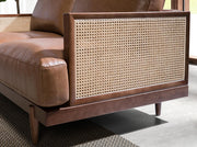 Barna színű marhabőrrel kárpitozott, rattanbetétes, 2 személyes design kanapé.