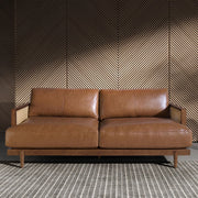 Barna színű marhabőrrel kárpitozott, rattanbetétes, 3 személyes design kanapé.