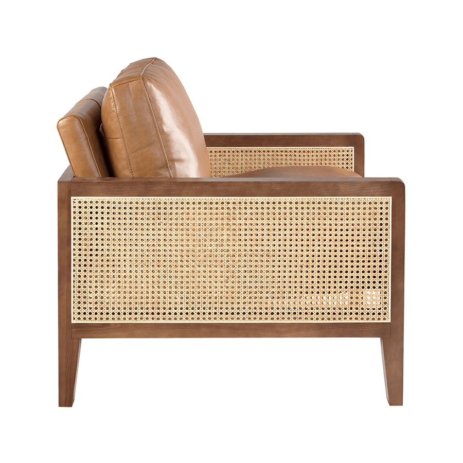 Konyakbarna színű marhabőrrel kárpitozott, rattanbetétes design fotel.