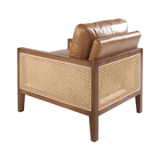 Konyakbarna színű marhabőrrel kárpitozott, rattanbetétes design fotel.