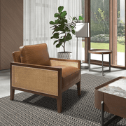 Konyakbarna színű marhabőrrel kárpitozott, rattanbetétes design fotel.