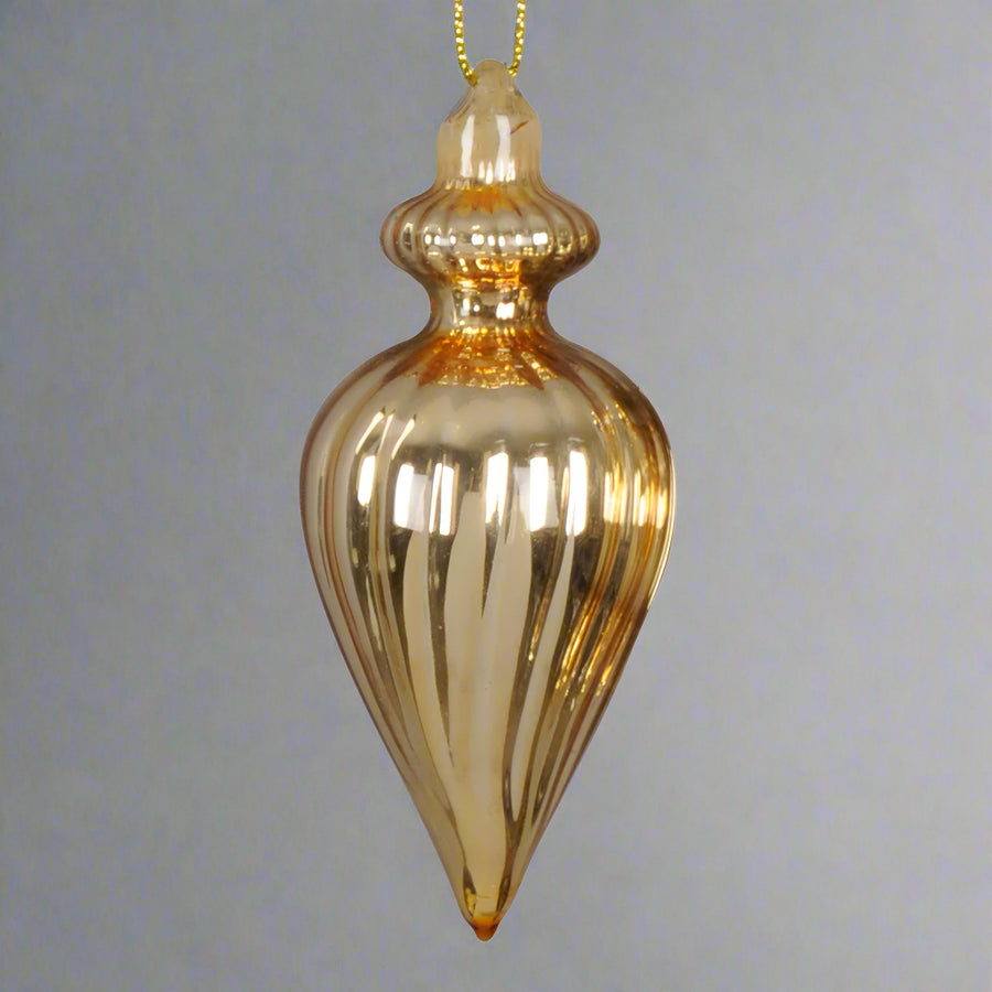 Bordázott, aranyszínű csepp alakú üveg karácsonyfadísz közelről.