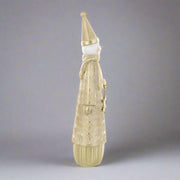 Oldalnézetből ábrázolt arany hóember figura, hosszú kúpos sapkával és arany ruhában.