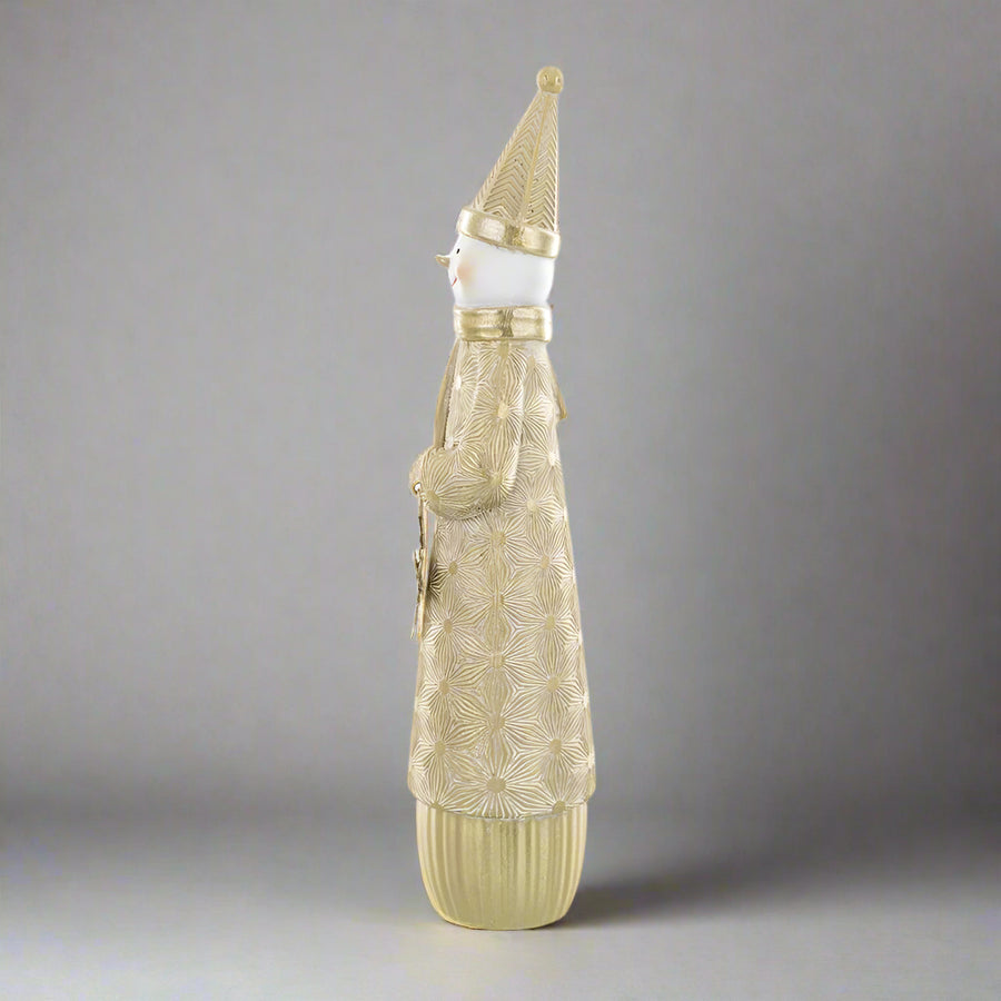 Másik oldalnézetből látható arany hóember figura, kezében csillogó hópehellyel.