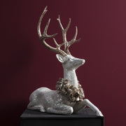 Pezsgőszínű tobozkoszorúval díszített fehér szarvas részletfotó