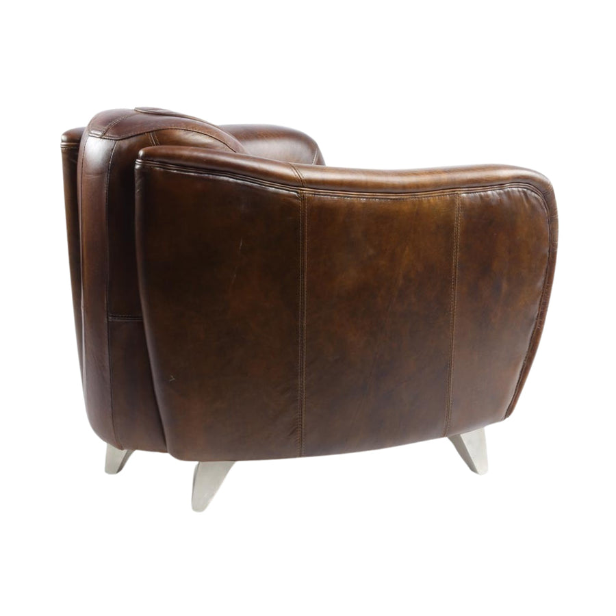 Háromnegyedes hátulnézet a fotelről, letisztult formával és ipari stílusú fém lábakkal.