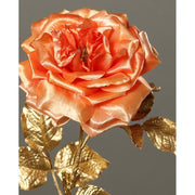 Fényes aranyszínű szárú és levelű, lazac színárnyalatú szatén rózsa művirág .