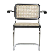 Modern fémvázas, fekete színű, rattan betétes karosszék.