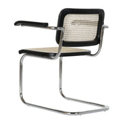 Modern fémvázas, fekete színű, rattan betétes karosszék.