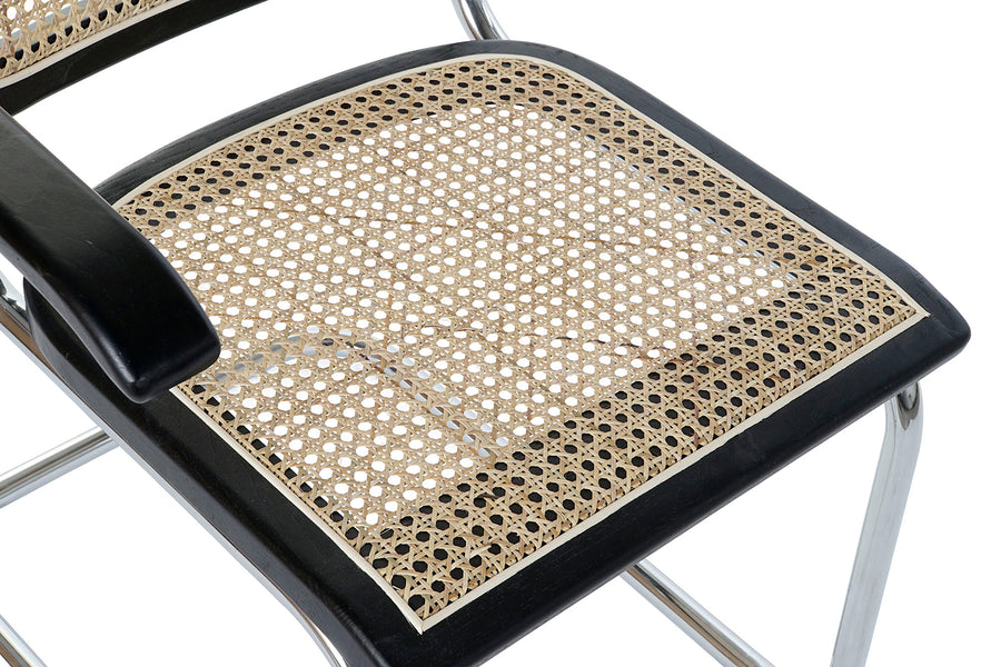 Modern fémvázas, fekete színű, rattan betétes karosszék.