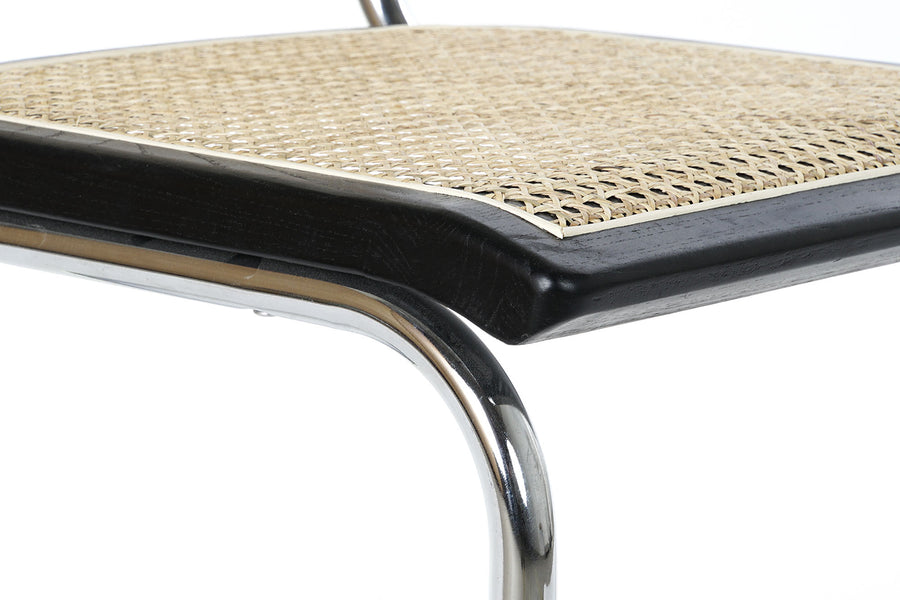 Modern fémvázas, fekete színű, rattan betétes karosszék.