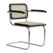 Modern fémvázas, fekete színű, rattan betétes karosszék.