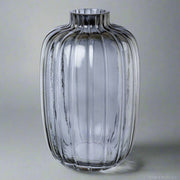 Kék bordázott üveg váza 30 cm magas, modern eleganciával. Letisztult dizájn stílusos otthonokhoz, dekorációként vagy vázaként is használható.