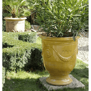 Sárga anduze kaspó leanderrel kertben.