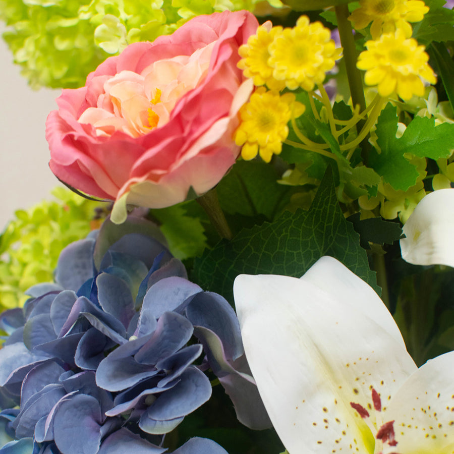 Vegyes művirágokból készült nagy virágcsokor, áttetsző üvegvázában.