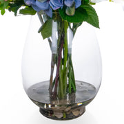 Vegyes művirágokból készült nagy virágcsokor, áttetsző üvegvázában.