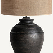 Fekete színű, égetett agyagból készült kézműves asztali lámpa.