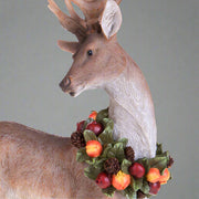 Gyümölcskoszorúval díszített, karácsonyi szarvas figura.