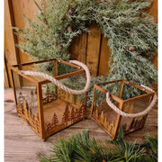 Vidéki rusztikus stílusú, antikolt rozsdás színű 2 darabos karácsonyi sziluettes fém lámpásszett fenyőkoszorú előtt antik faasztalon