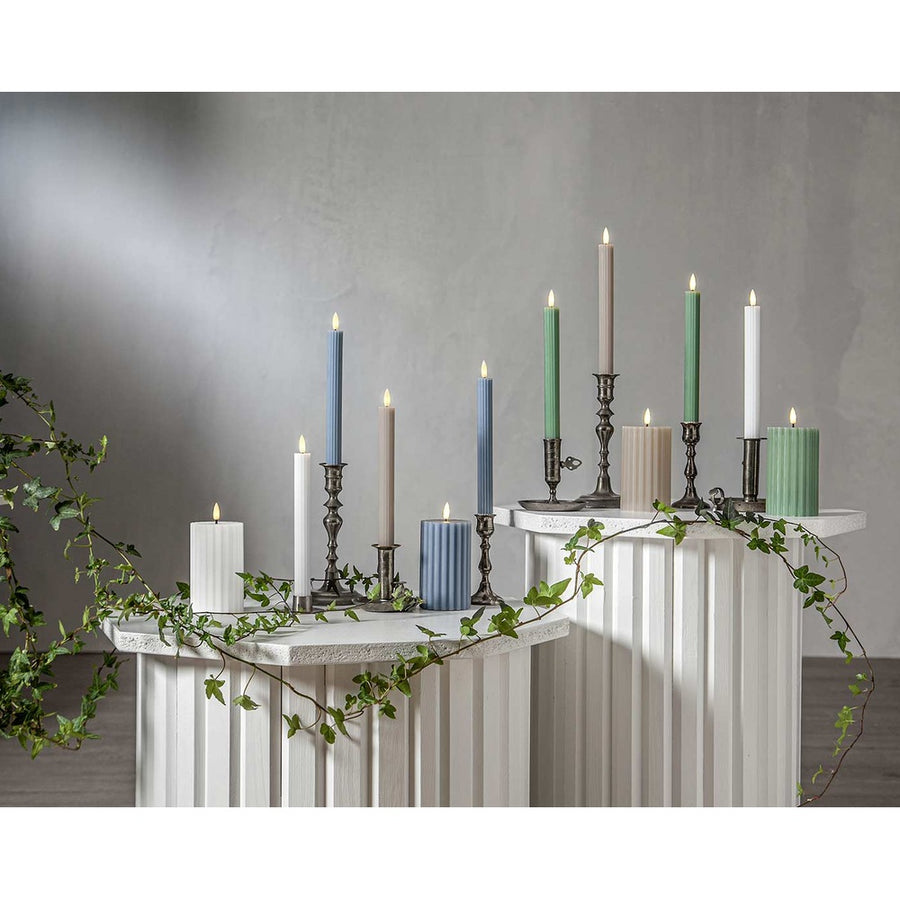 Stripe LED gyertya kollekció különböző méretű és színű valódi viaszból készült kannelúrás gyertyákkal, vintage gyertyatartókban elhelyezve, meleg fényű LED lánggal.