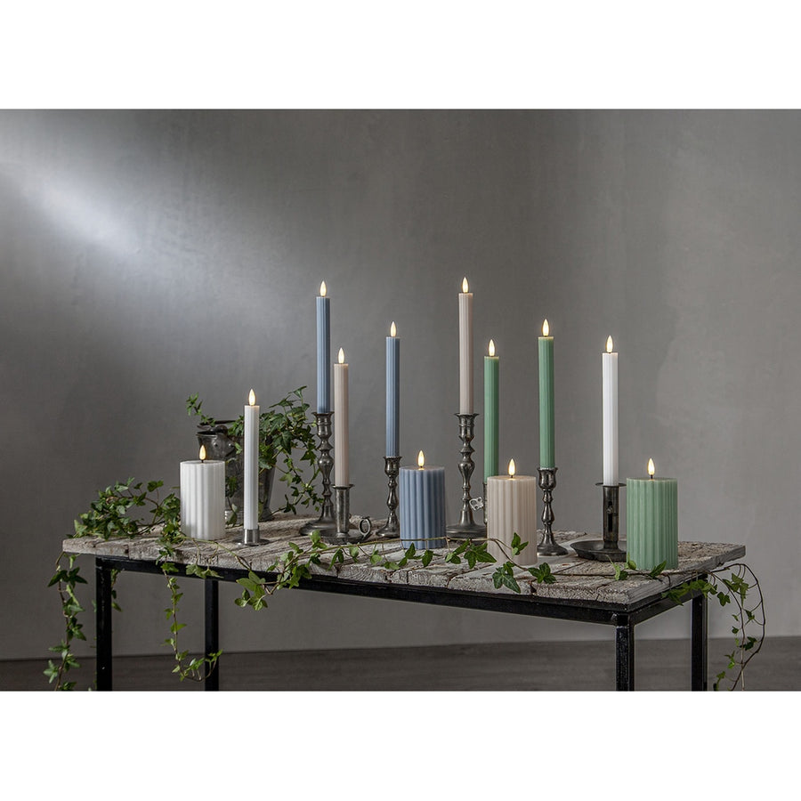 Stripe LED gyertya kollekció különböző méretű és színű valódi viaszból készült kannelúrás gyertyákkal, vintage gyertyatartókban elhelyezve, meleg fényű LED lánggal.