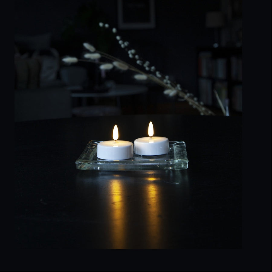 2 darab LED-es teamécses sötét asztalon.