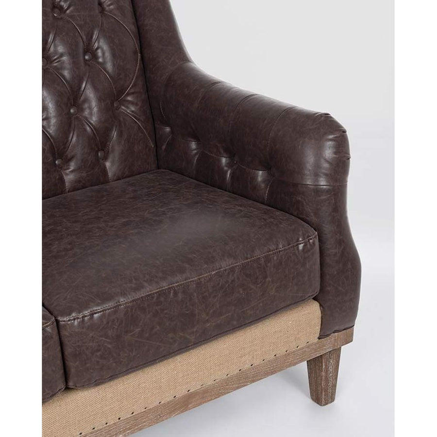 Loft stílusú, sötétbarna bőrrel kárpitozott kőrisfa kanapé karfa részlete.