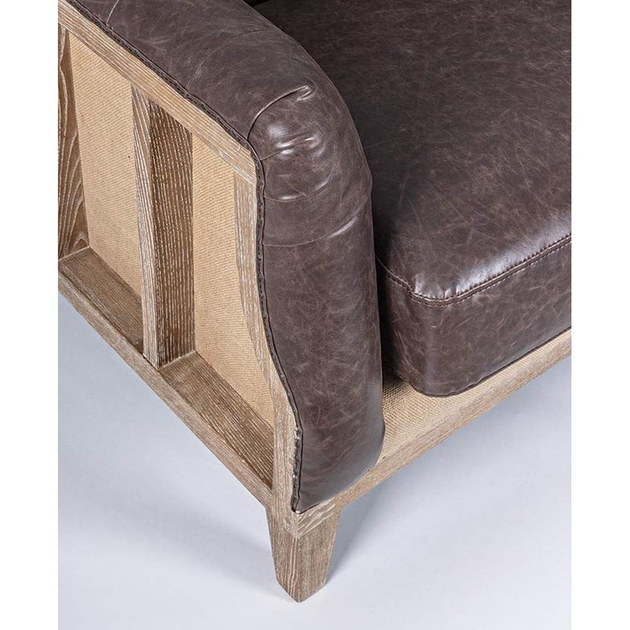 Loft stílusú, sötétbarna bőrrel kárpitozott kőrisfa kanapé karfa része.
