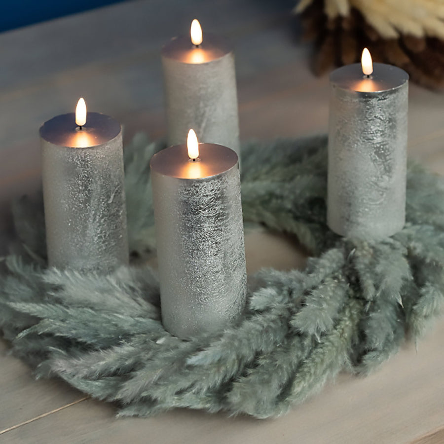 Ezüstszínű LED gyertyák fenyőkoszorún.