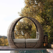 Egy medence szélén álló kerti pihenőágy összetolva.