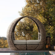 Egy medence szélén álló kerti pihenőágy összetolva.