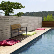 Medence szélén álló fémvázas kerti pad.